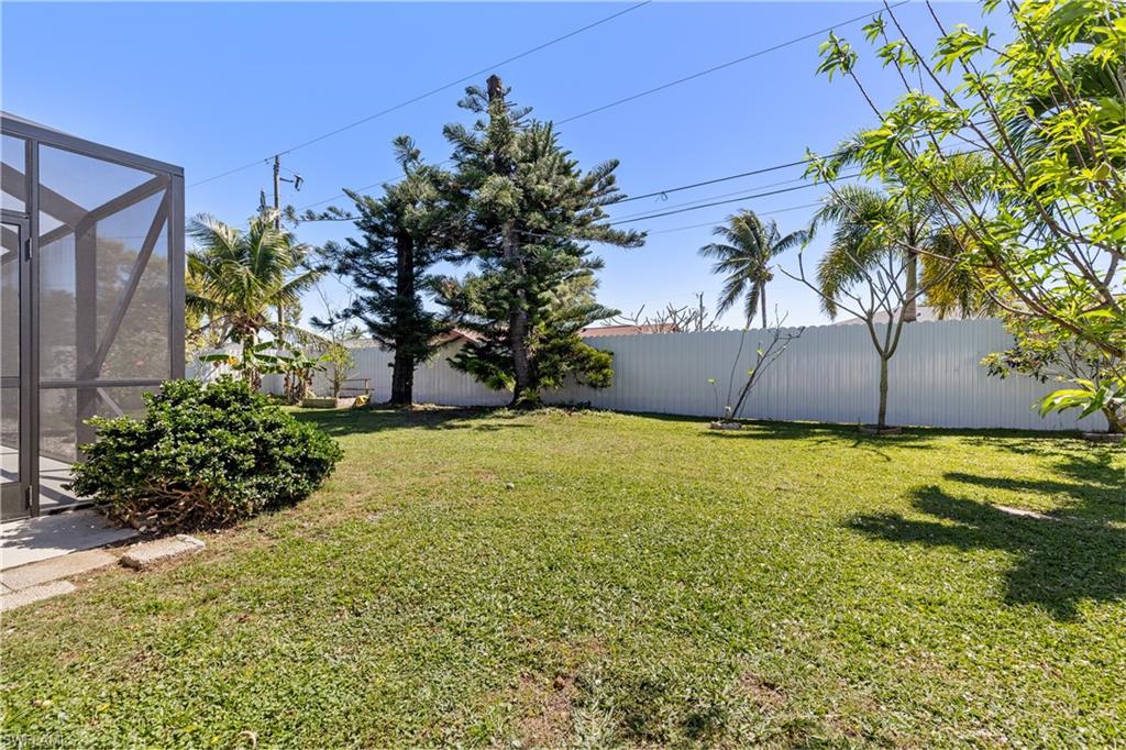 View of yard with a lanai and fence