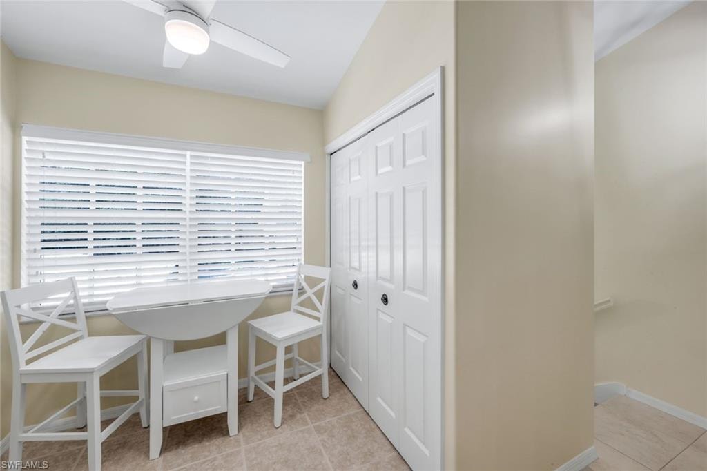 Full Washer/Dryer off Dining space featuring light tile patterned flooring and a ceiling fan