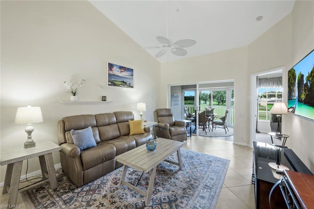 Living area featuring Reclining Couch, Chair, Roomba, light tile patterned flooring, high vaulted ceiling, and a ceiling fan