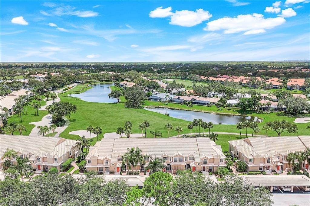 Aerial view of residential area featuring a nearby body of water and a golf club
