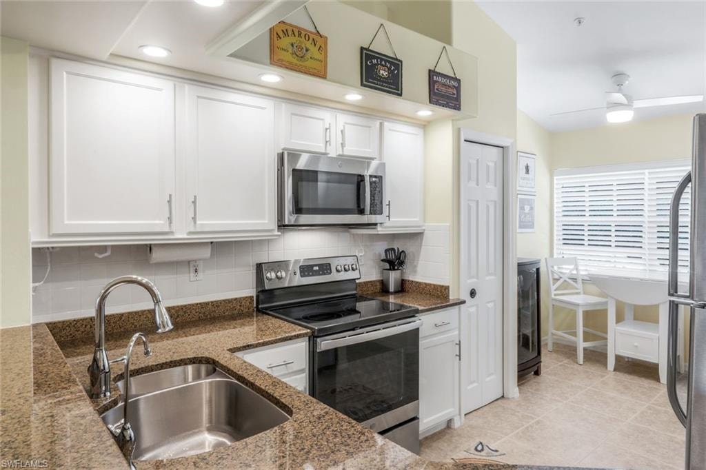 Kitchen with granite countertops stainless steel appliances, white cabinetry, tasteful backsplash, a ceiling fan, and recessed lighting