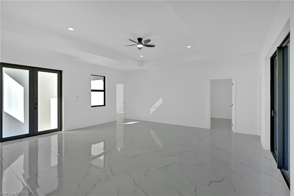 Expansive room featuring polished tile flooring, recessed lighting, a ceiling fan, and multiple large windows with dark frames