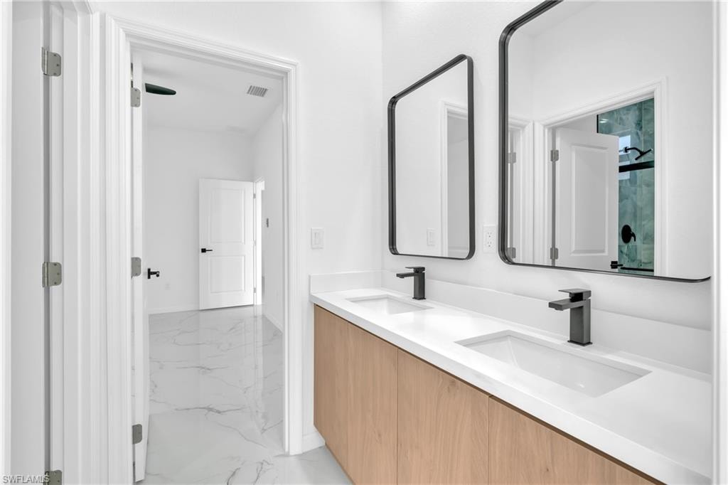 Dual vanity with integrated sinks, matte black faucets, and wood-finish cabinetry
