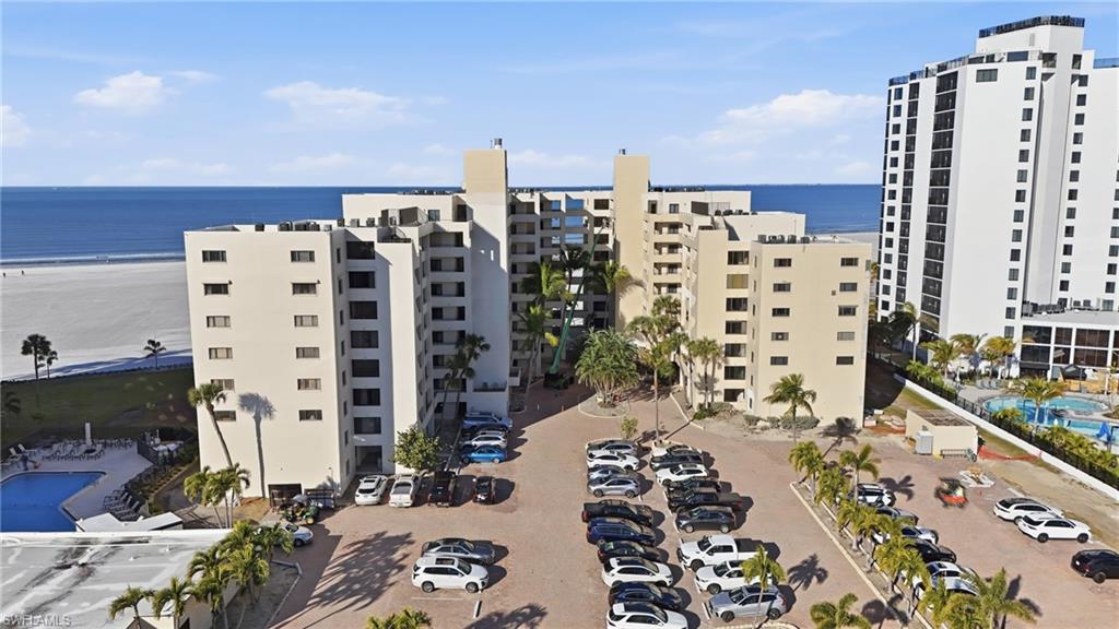 View of apartment building / complex with a water view and uncovered parking