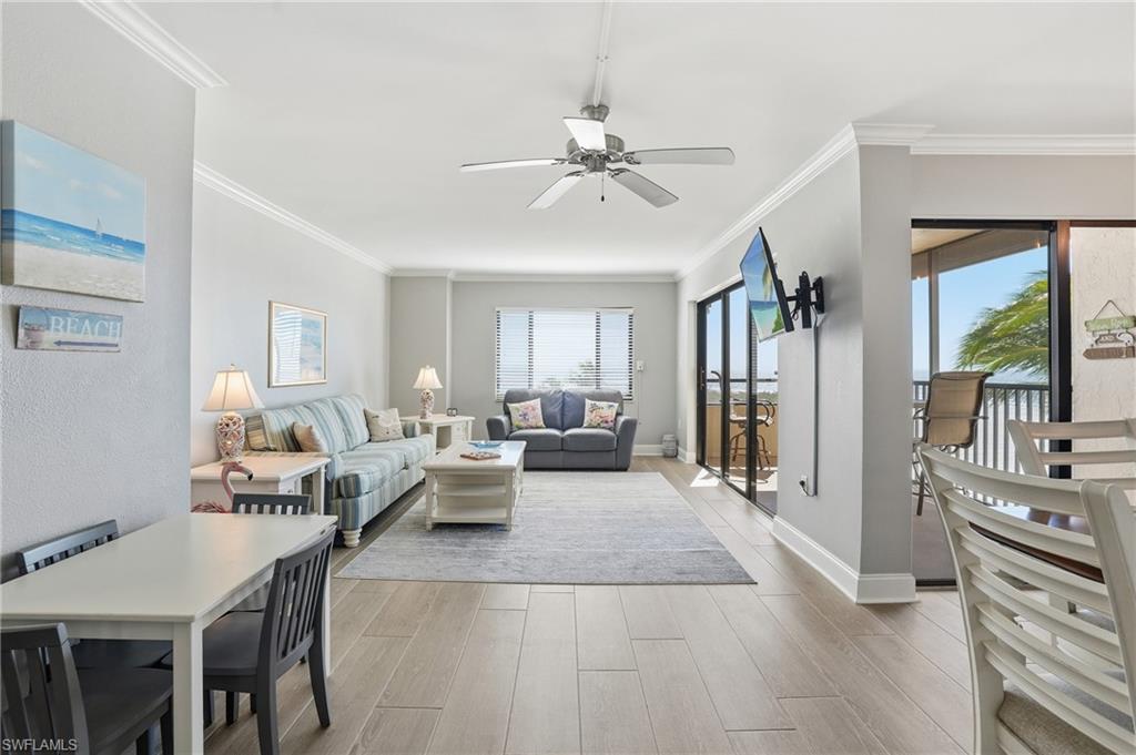 Living area with light wood finished floors, a ceiling fan, and ornamental molding