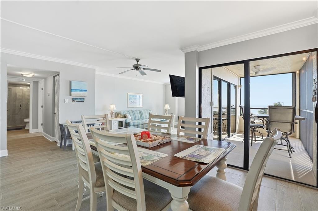 Dining space featuring light wood-style floors, ornamental molding, and ceiling fan