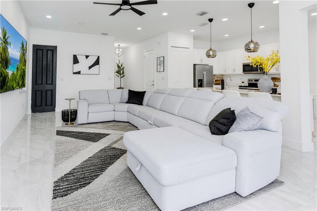 Open-concept living area with tile flooring and recessed lighting