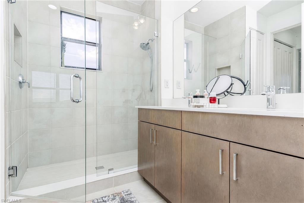Glass-enclosed shower with tile surround and window