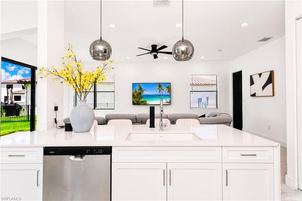 Kitchen island featuring a single-basin sink, stainless steel faucet, and integrated dishwasher