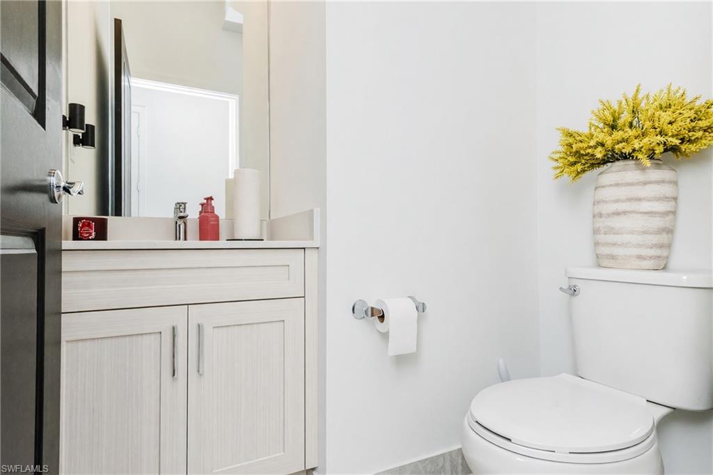 Light-toned vanity with double cabinet doors, chrome hardware, and a single basin sink