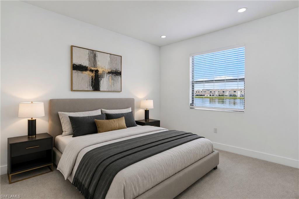Recessed lighting, window with blinds, lake scenery, wall-to-wall carpeting, and white walls