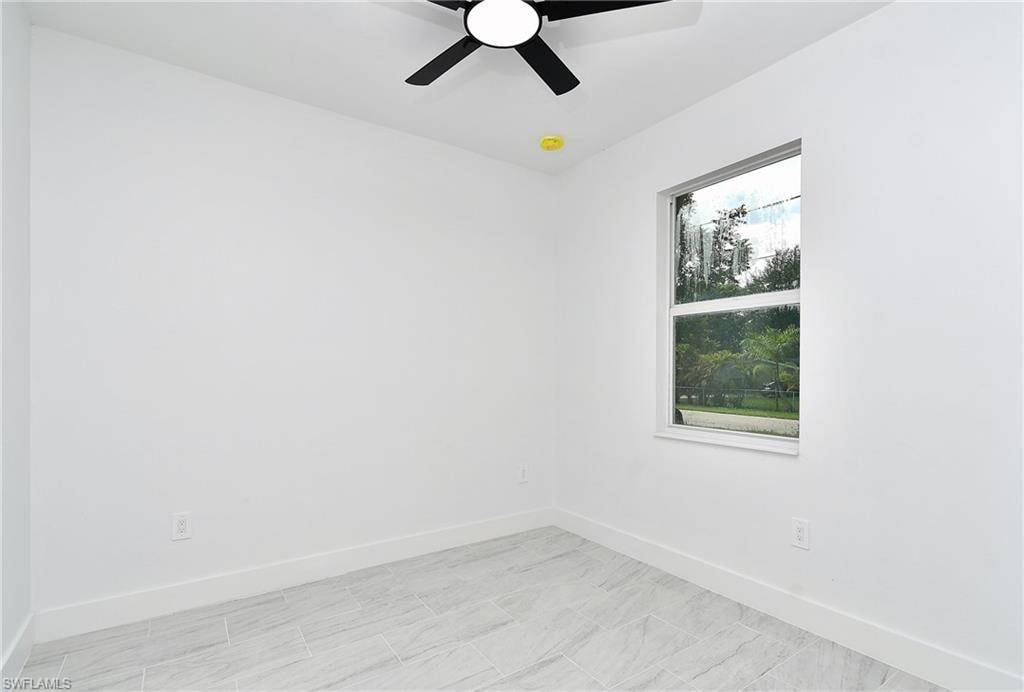 White walls, tile flooring, and a ceiling fan with integrated lighting