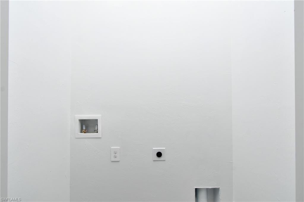 White wall finish, laundry hookup box, electrical outlet, dryer vent hookup