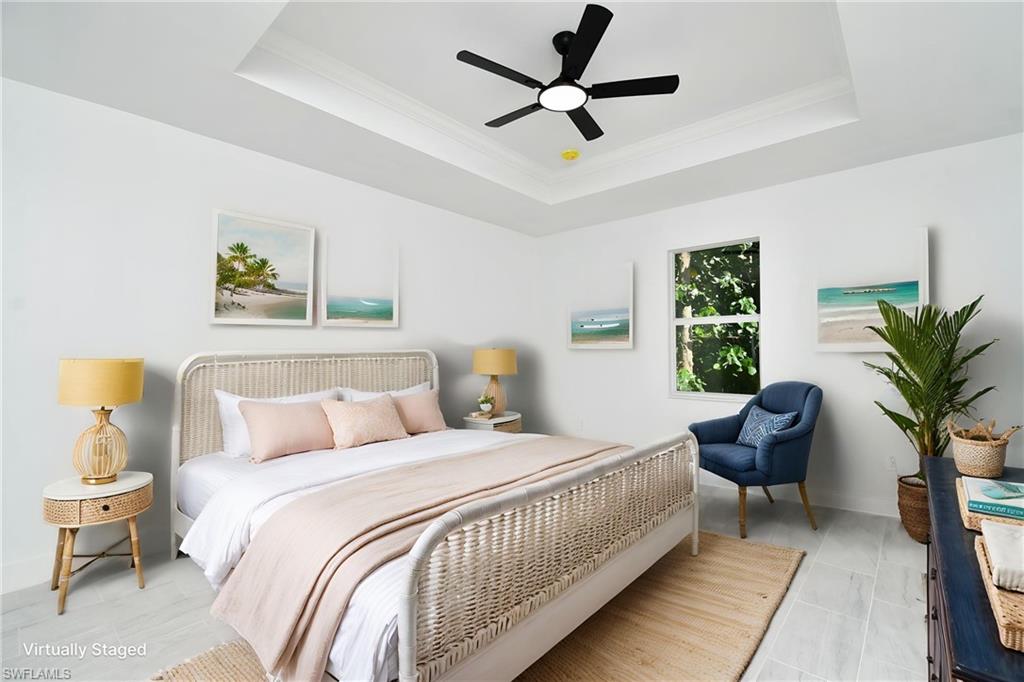 Recessed ceiling with crown molding, ceiling fan with integrated lighting, wood-finish flooring, and a window with natural light