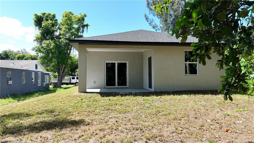 Stucco exterior with a covered patio and sliding glass doors