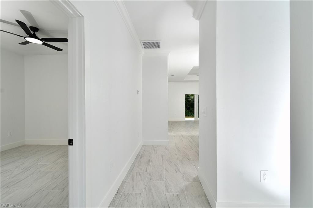 White tile flooring throughout, white baseboards, and crown molding