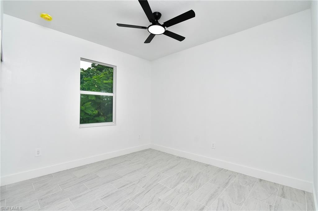 Recessed window, white walls, ceiling-mounted fan with integrated lighting, and tile flooring