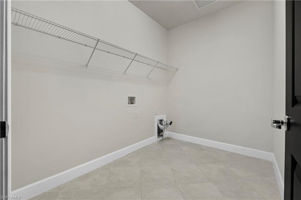 Laundry utility space featuring tile flooring and a wire shelving system