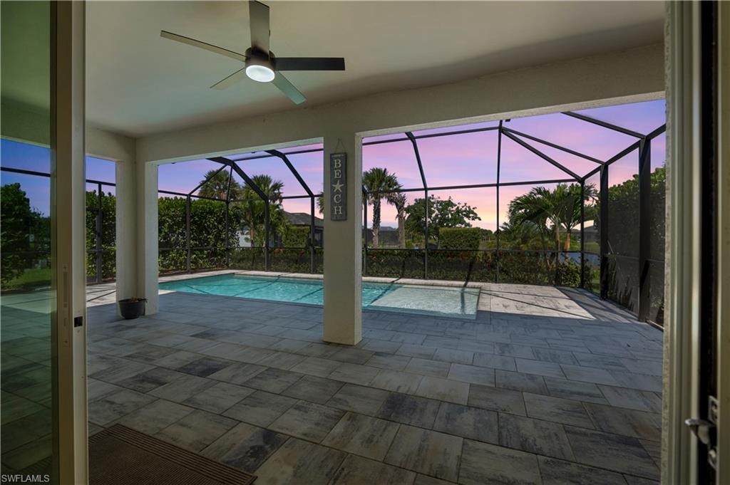 Covered lanai with ceiling fan, screened enclosure, swimming pool, and spa
