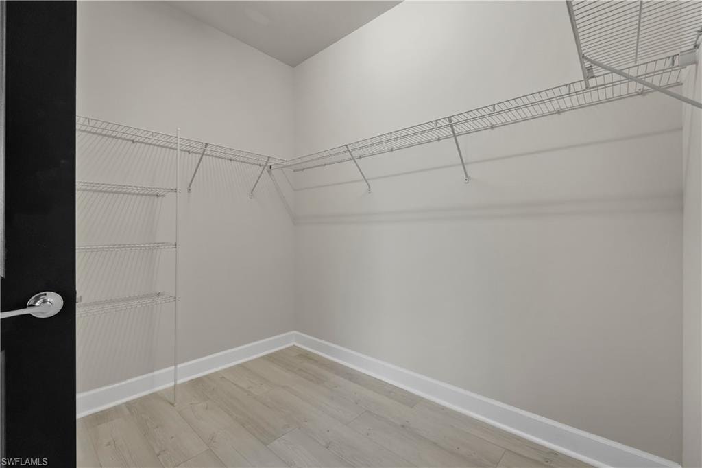 Corner closet with wire shelving and natural wood-finish flooring