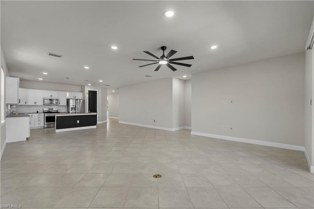 Open-concept living space featuring neutral tile flooring and recessed lighting