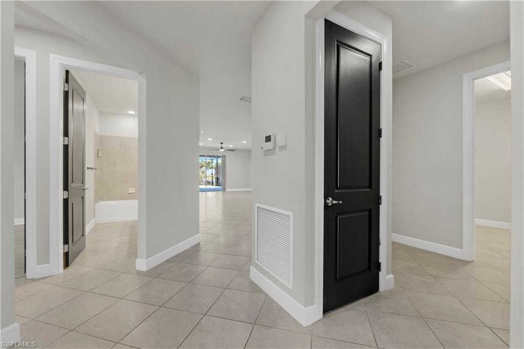 Neutral tile flooring with clean white baseboards, featuring contrasting dark panel doors