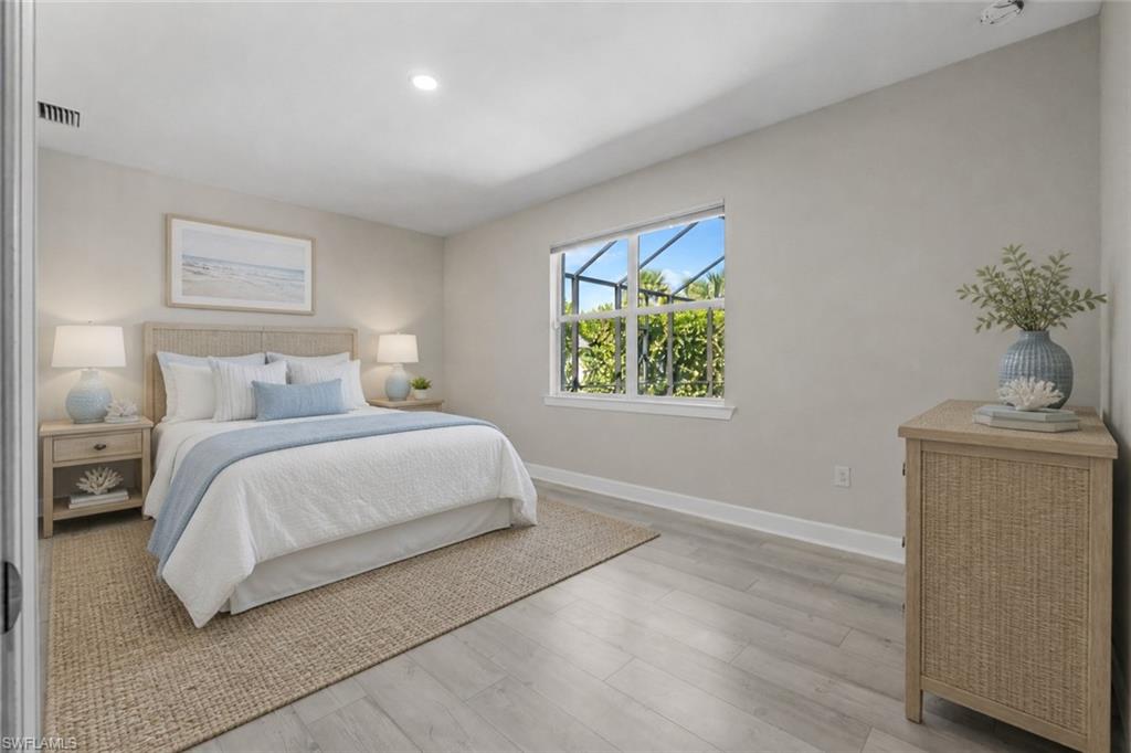 Recessed lighting, wood-finish flooring, and a large window with white trim