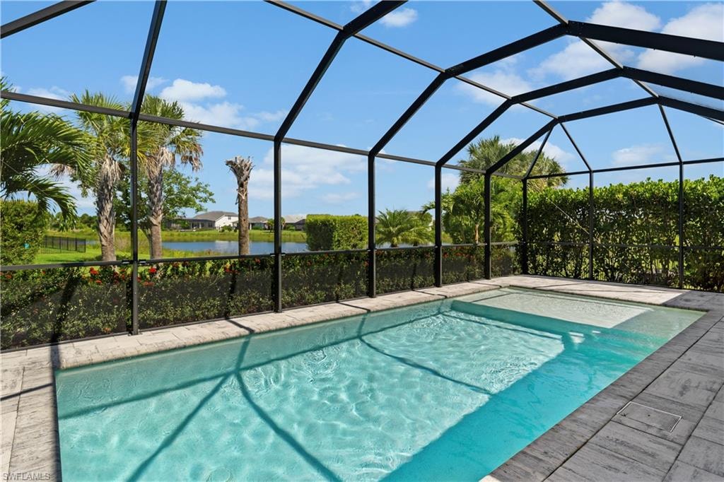 Screened enclosure featuring a clear blue swimming pool and integrated spa