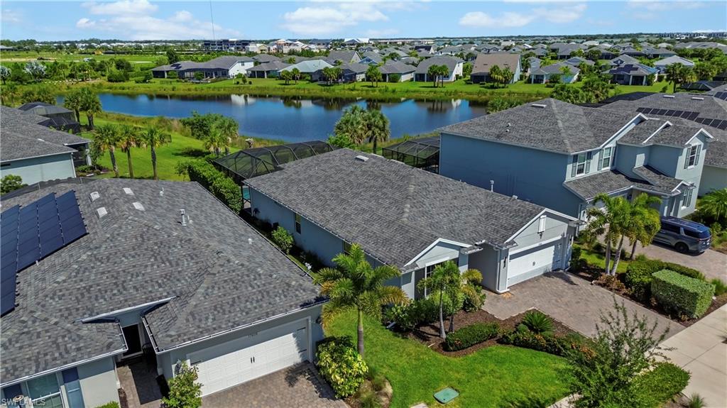Single-family residence with a paver driveway, an attached garage, and landscaping
