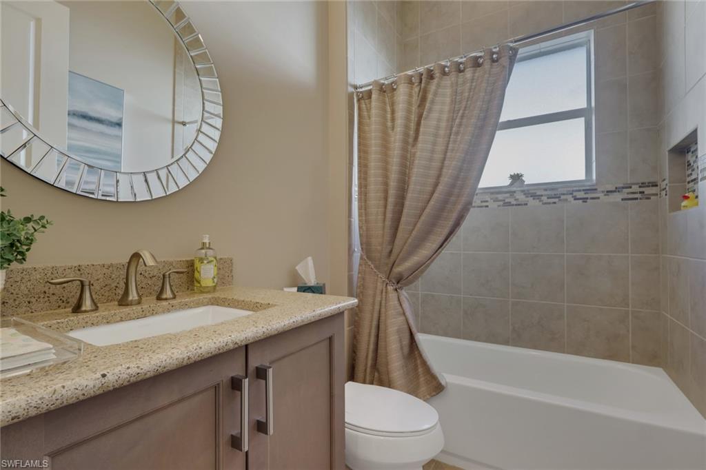 Vanity with a light-toned countertop, under-mount sink, and dual-handle faucet