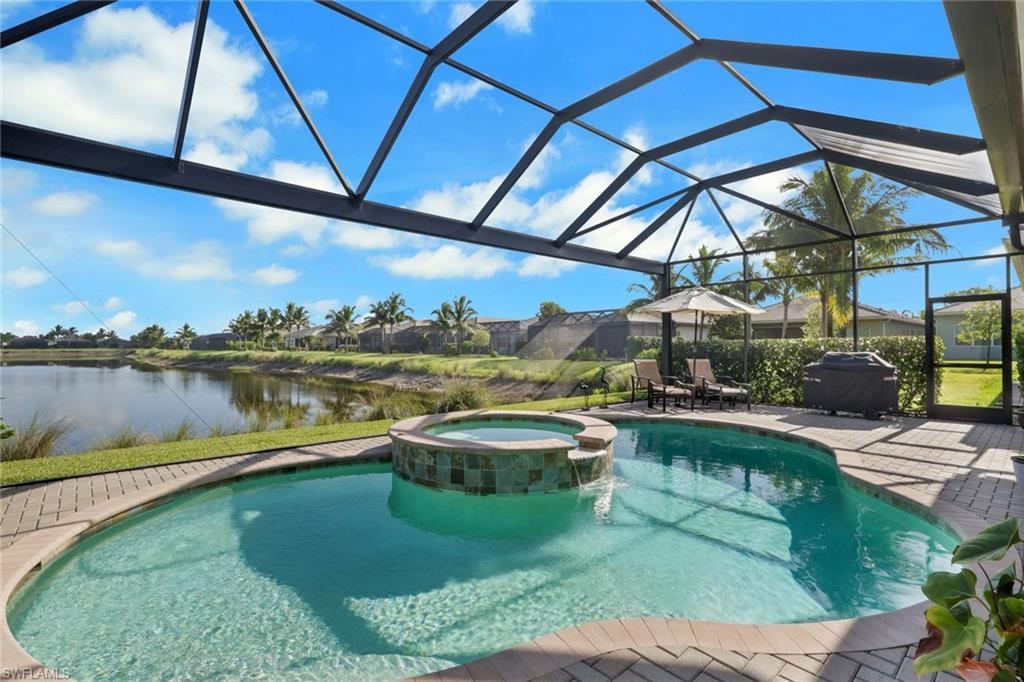 Screened-in outdoor living space with a pool, integrated spa, and paver decking