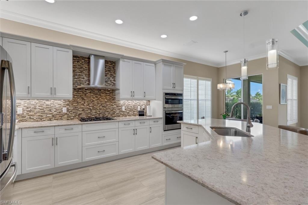 Kitchen featuring light-toned cabinetry, light-toned countertops, tile backsplash, built-in double ovens, and recessed lighting