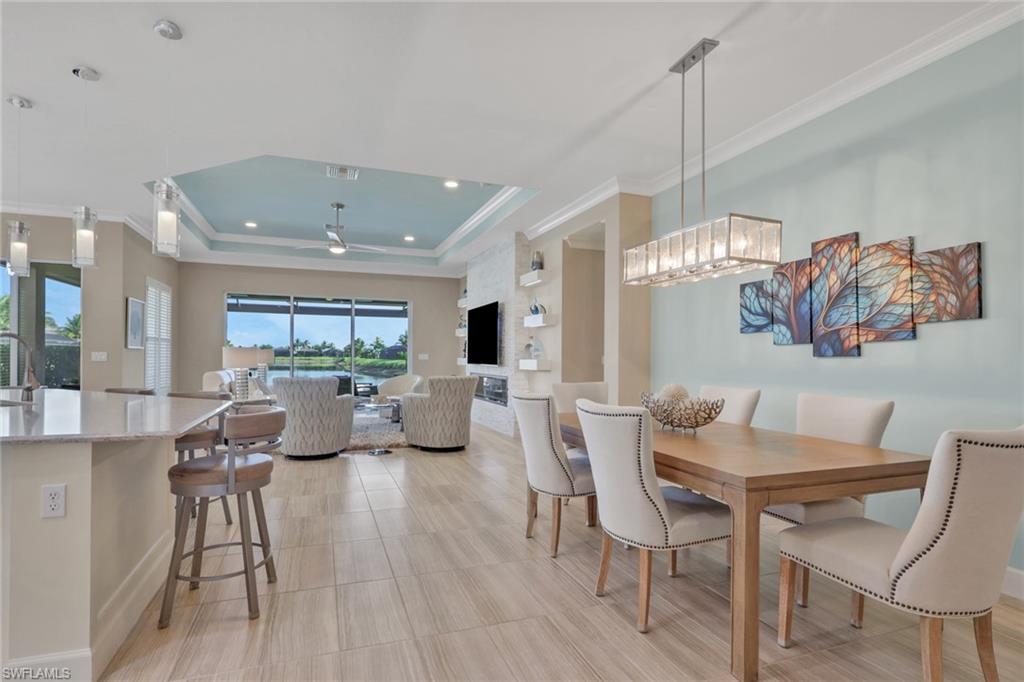 Open concept living area with wood-finish flooring, tray ceiling, and built-in shelving