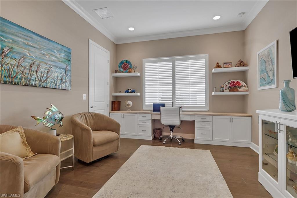 Built-in desk and cabinetry with wood-finish countertops, plantation shutters, and recessed lighting
