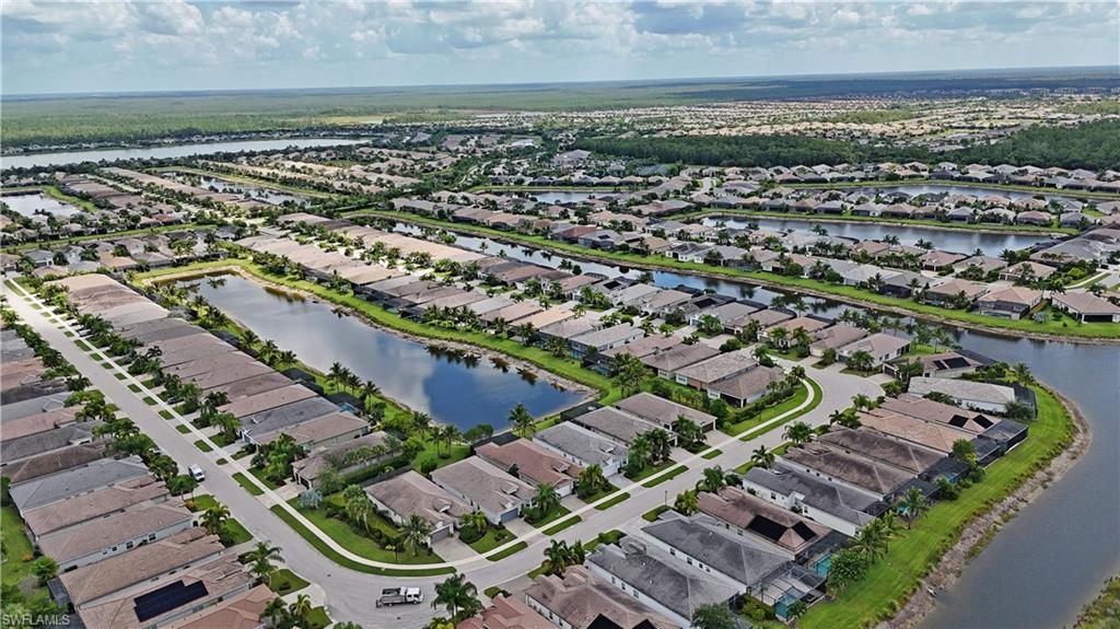 Residential development featuring numerous single-family homes, multiple interconnected waterways, paved roadways, and landscaped common areas