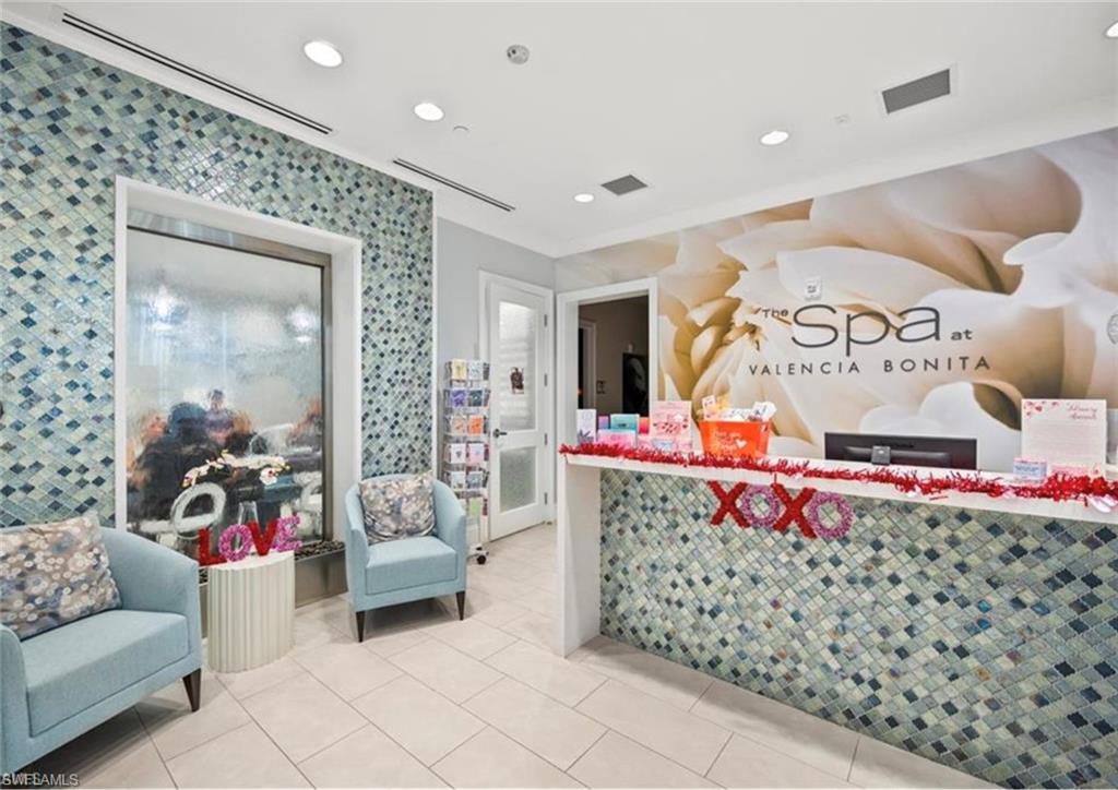 Reception area with mosaic tile accents, recessed lighting, and large format floor tile