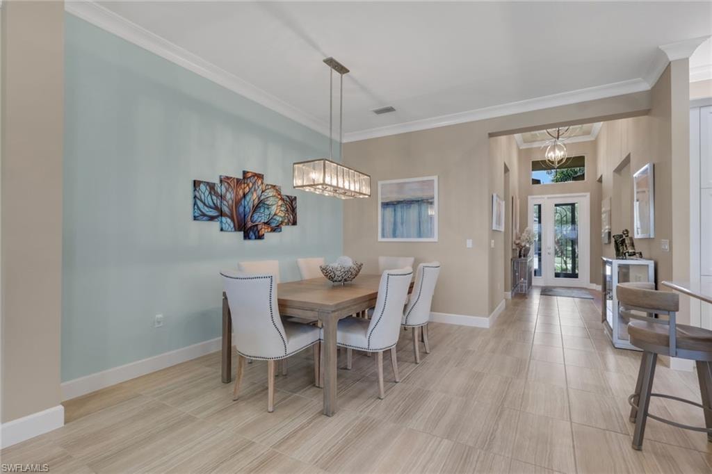 Light wood-finish flooring, crown molding, and a high ceiling