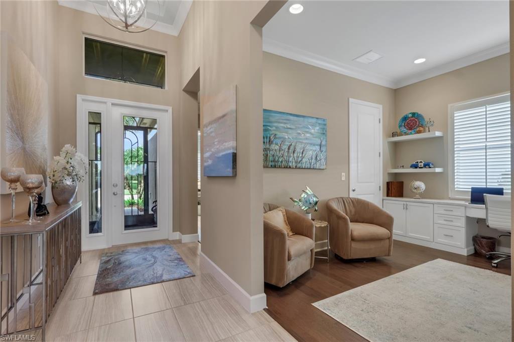 Grand foyer with high ceilings and transom window, featuring tile flooring and an elegant overhead light fixture