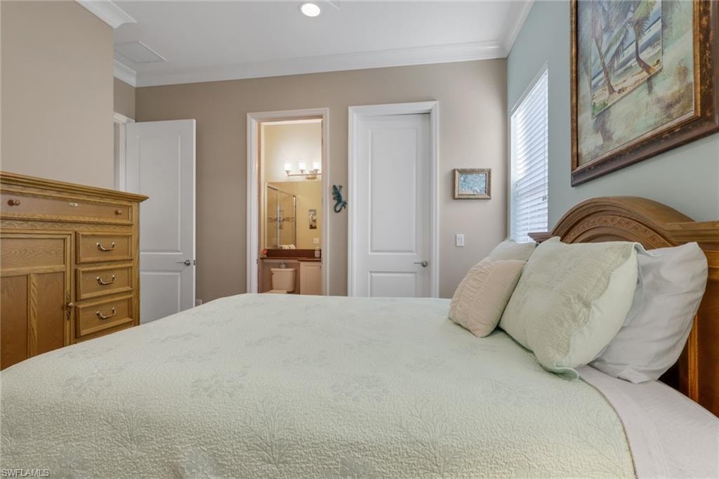 Recessed lighting, crown molding, and a visible bathroom entry featuring a vanity with an undermount sink and a glass-enclosed shower