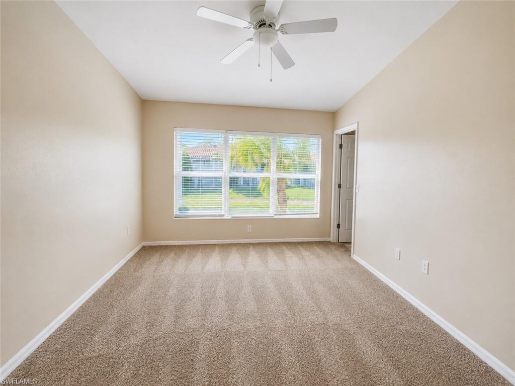 Carpeted flooring, window with blinds, ceiling fan with light fixture, and neutral wall tones