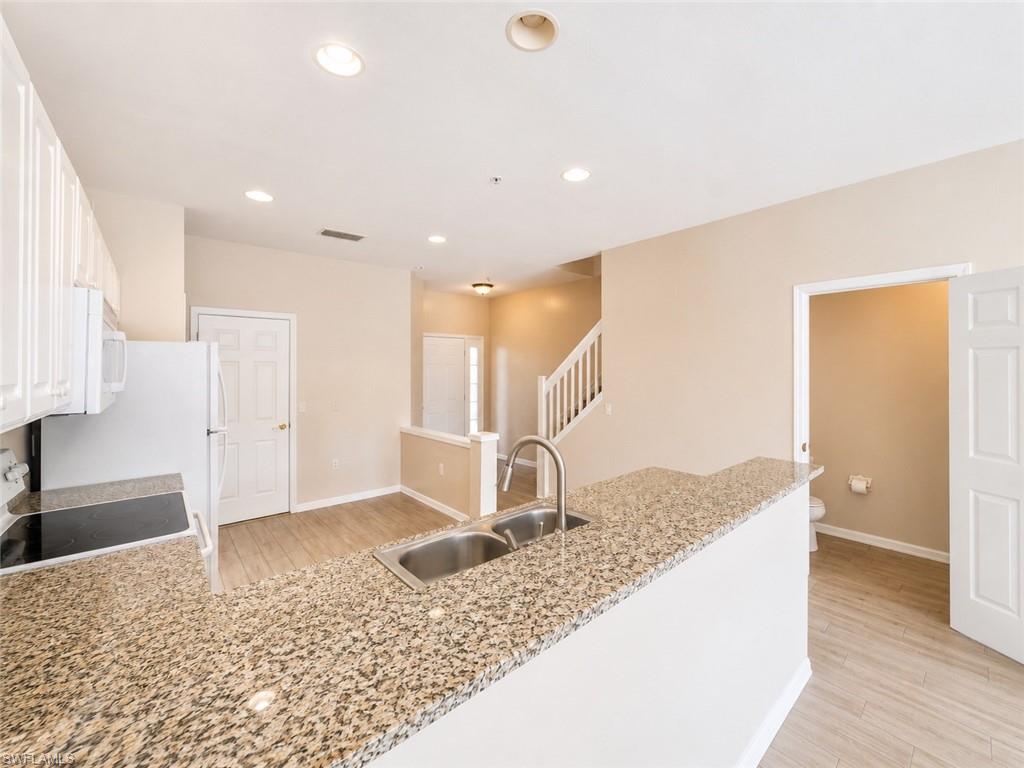 Kitchen featuring ample counter space, a double basin sink, white cabinetry, and stainless steel appliances