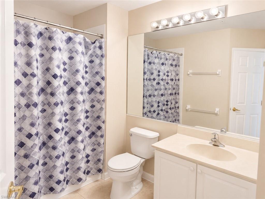 Bathroom featuring a built-in vanity with an integrated sink, a wall-mounted mirror, overhead lighting, and a white toilet