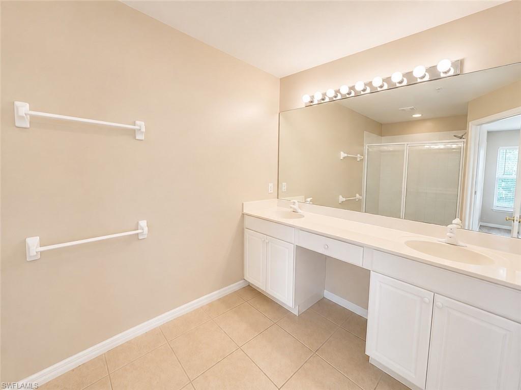 Dual vanity with integrated sinks, white cabinetry, and a full-width mirror