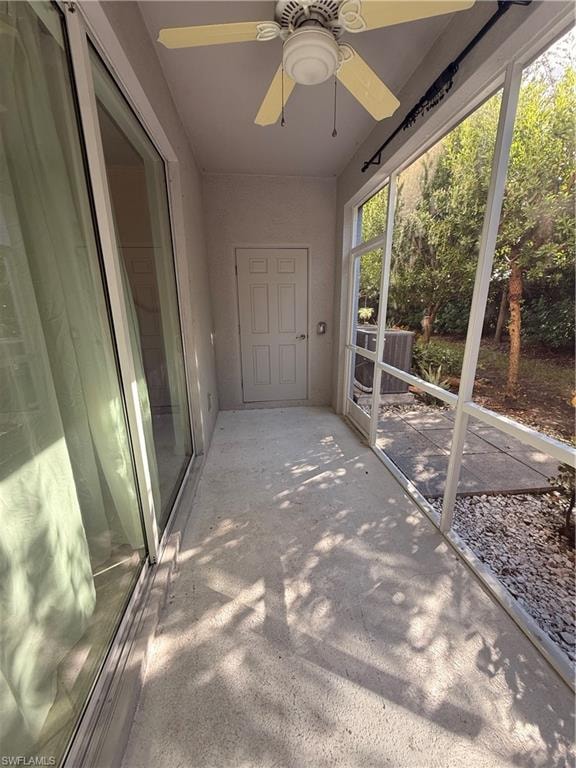 Screened outdoor patio featuring a ceiling fan, concrete flooring, and sliding glass doors