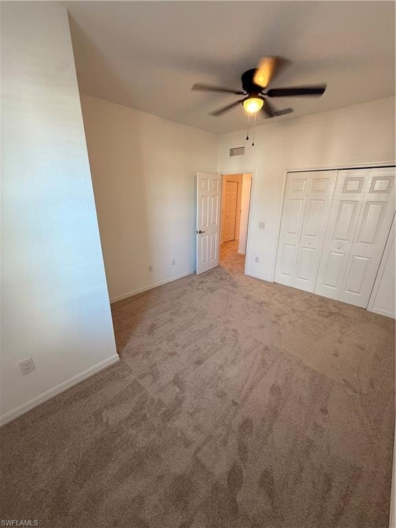 Plush carpeted flooring, a ceiling fan with integrated lighting, and multiple closet storage options
