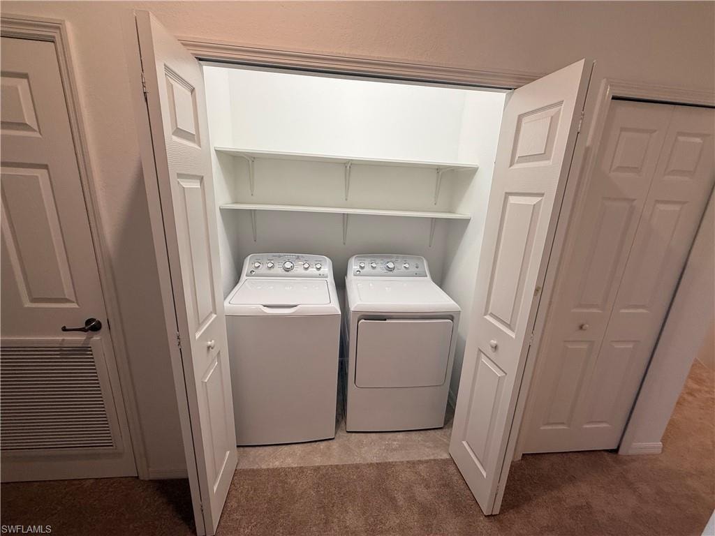 Laundry closet with bifold doors, integrated shelving, and carpet flooring
