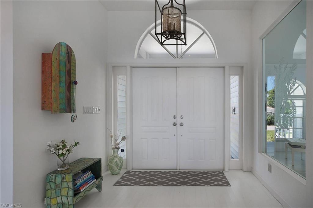 Double entry doors featuring decorative paneling, transom window, and sidelights