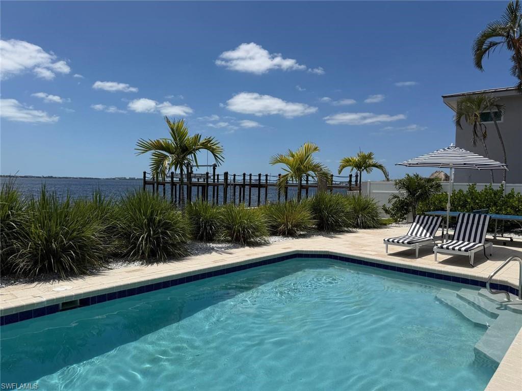 In-ground swimming pool with integrated steps, surrounded by light-toned paver decking