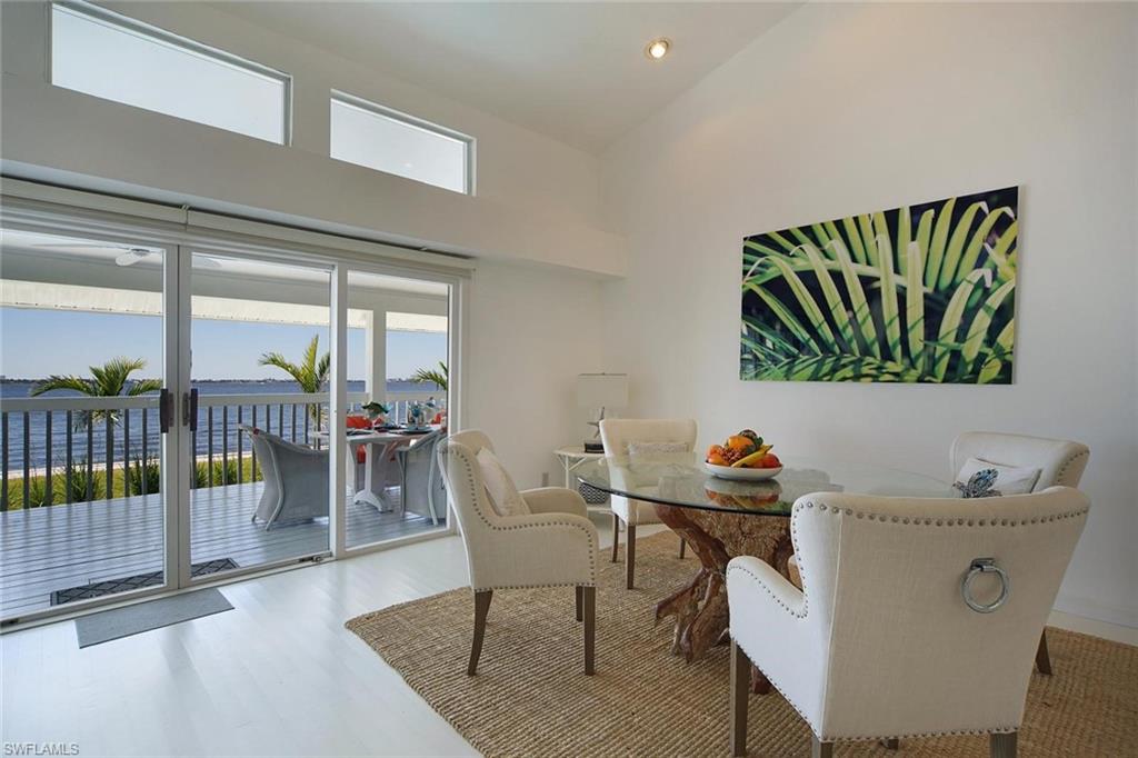 Interior dining area with vaulted ceiling and light-color flooring