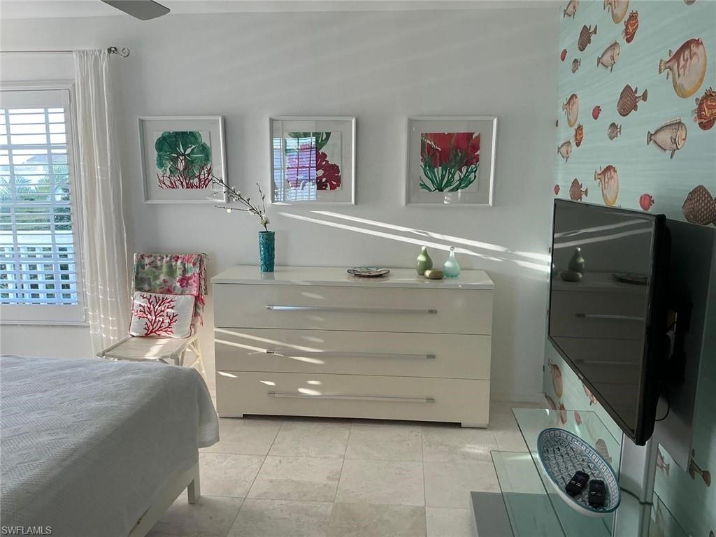 White plantation shutters, ceiling fan, and tile flooring